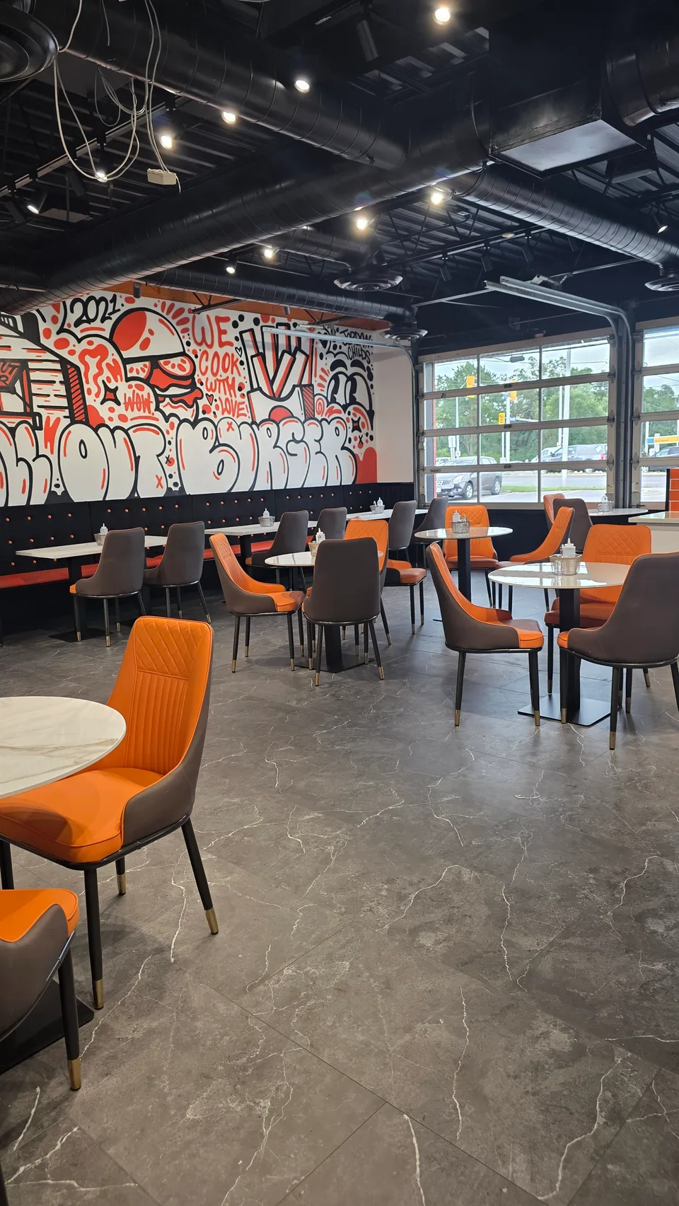 Orange seating and All-Out Burger mural at the Bank Street restaurant